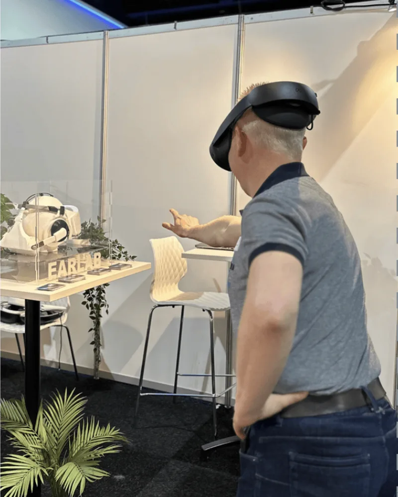 Een bezoeker met een VR-bril bij de Earlab-stand, van achteren gezien